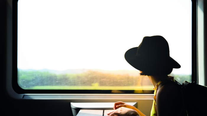 A beautiful hipster asian woman travelling on the train. Sitting on the black leather cozy comfort seat in the business class boky of the train in Europe. Tourist travel concept.; Shutterstock ID 1111543499; Purchase Order: -