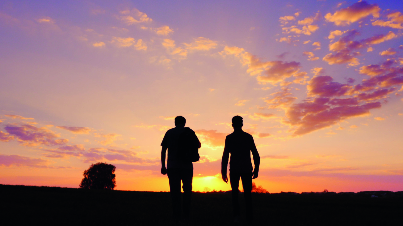 Silhouettes of two men - son and father go together to meet the sunset. Back view.; Shutterstock ID 1071227588; Purchase Order: purchase_order