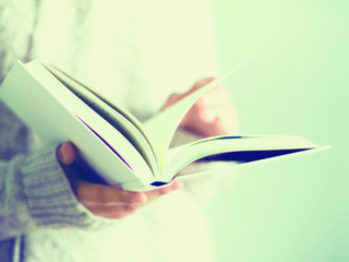 Young girl in white cardigan reading opened book. Copy space. lifestyle and school concept. Banner.; Shutterstock ID 790024390; Purchase Order: purchase_order