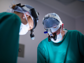 Surgeons wearing surgical loupes while performing operation in operation theater