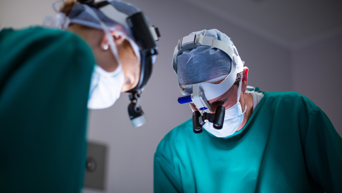 Surgeons wearing surgical loupes while performing operation in operation theater